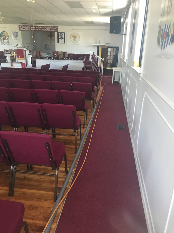 A room filled with red chairs and a carpeted floor on the left side.